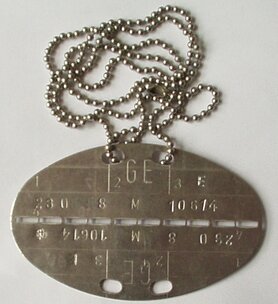 Der Volksbund Deutsche Kriegsgräberfürsorge e.V. findet jährlich etwa 20.000 im Krieg gefallene und verschollene Soldaten und gibt ihnen eine Ruhestätte. Diese können anhand ihrer Erkennungsmarke mit Metalldetektoren gefunden und identifiziert werden. https://commons.wikimedia.org/wiki/File:BW_Erkennungsmarke_1982.jpg KarleHorn, CC BY-SA 3.0 DE BW_Erkennungsmarke_1982